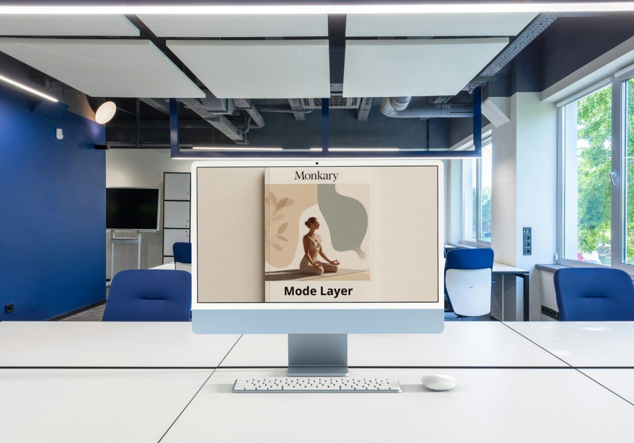 Computer monitor displaying a Monikary Mode Layer advertisement in an office setting.