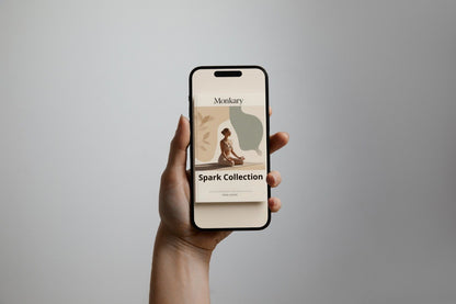 Hand holding a smartphone displaying an app interface with 'Monitory' and 'Spark Collection' text on a gray background.